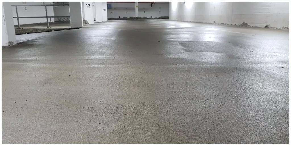 Baustellenboden mit rohem Zementschleier vor der Reinigung.